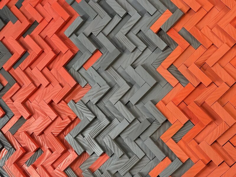 Close-up of handcrafted orange and gray herringbone wood art in the VOLTAGE office