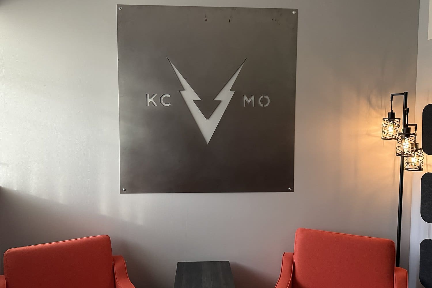 Steel KC V MO sign above orange lounge chairs in the VOLTAGE office